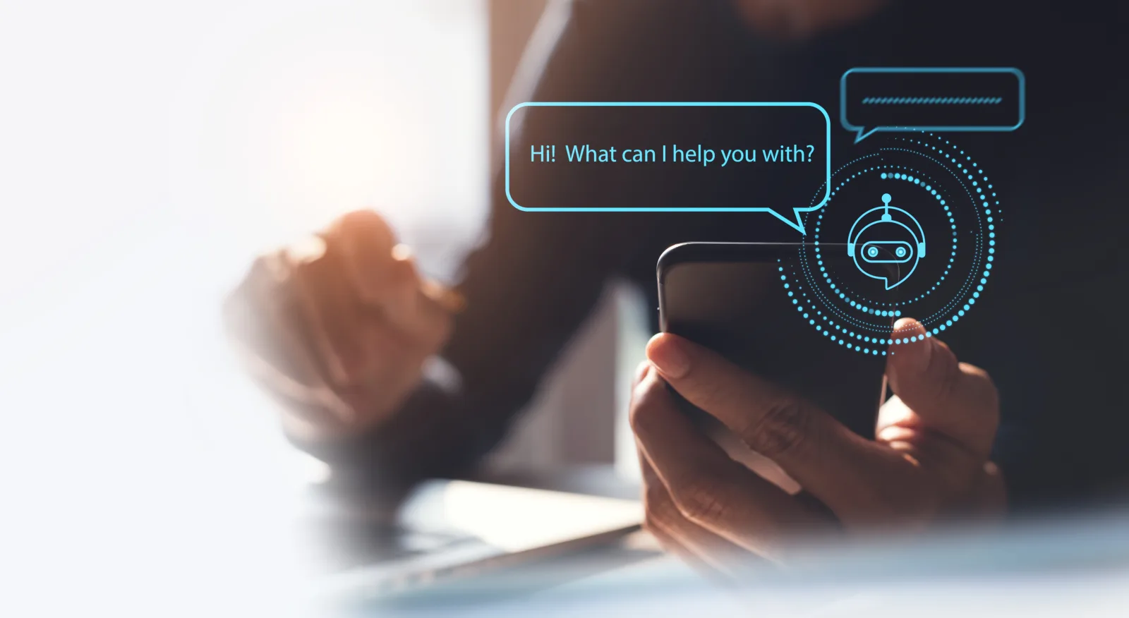Main tenant un smartphone affichant un assistant virtuel et le message Hi What can I help you with